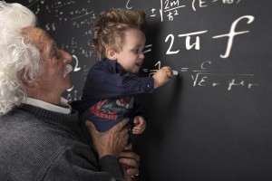 Nonno scienziato con nipotino in braccio che scrive alla lavagna