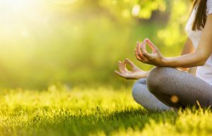 woman in yoga pose in park with sunshine